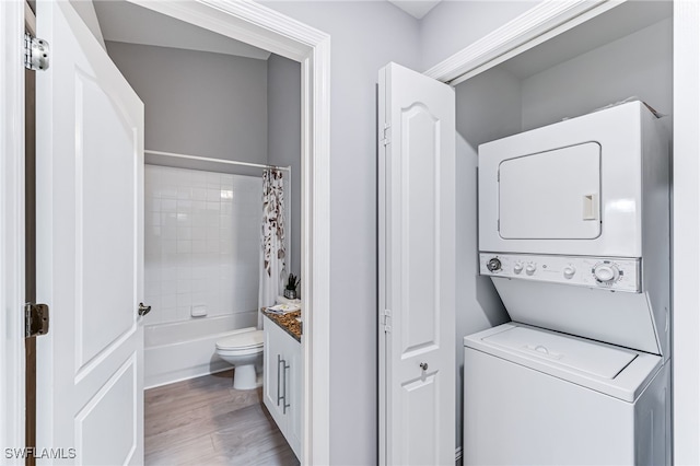 laundry room featuring light hardwood / wood-style floors and stacked washer / drying machine