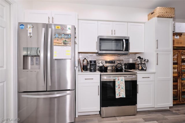 kitchen featuring white cabinets, light hardwood / wood-style floors, stainless steel appliances, and tasteful backsplash