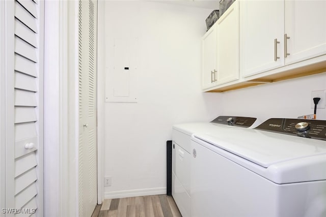 clothes washing area featuring cabinets, independent washer and dryer, electric panel, and light hardwood / wood-style flooring