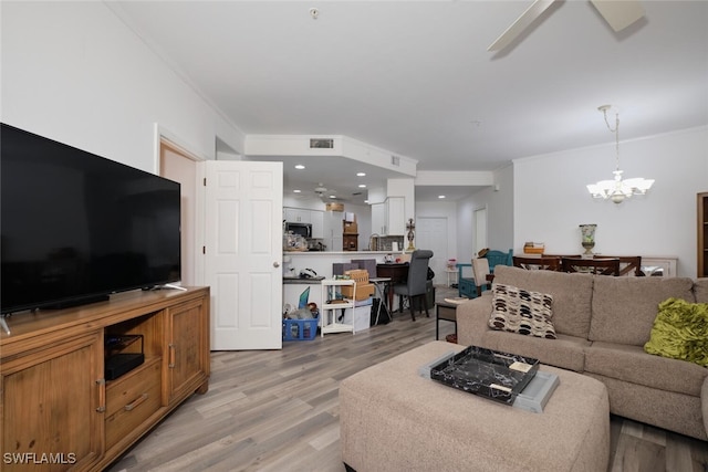 living room with hardwood / wood-style floors and ceiling fan with notable chandelier