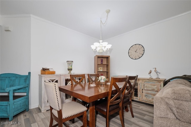 dining space with hardwood / wood-style flooring, crown molding, and an inviting chandelier