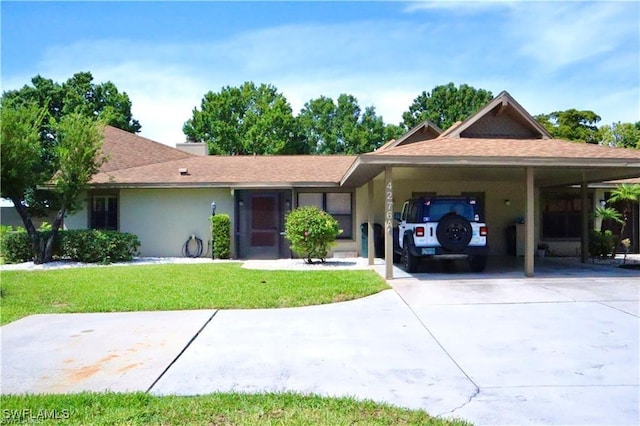 view of front of home with a carport and a front lawn