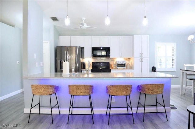 kitchen featuring black appliances, white cabinets, sink, and tasteful backsplash