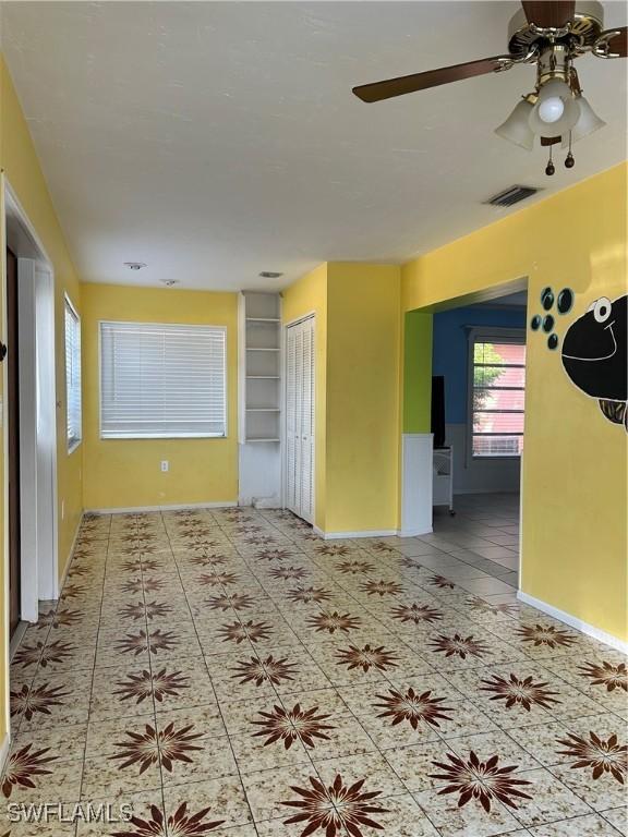 tiled spare room featuring ceiling fan