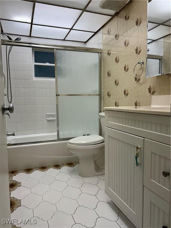 full bathroom with vanity, toilet, and combined bath / shower with glass door