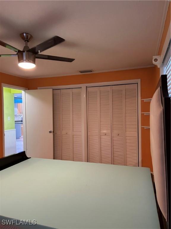 unfurnished bedroom featuring ceiling fan and multiple closets