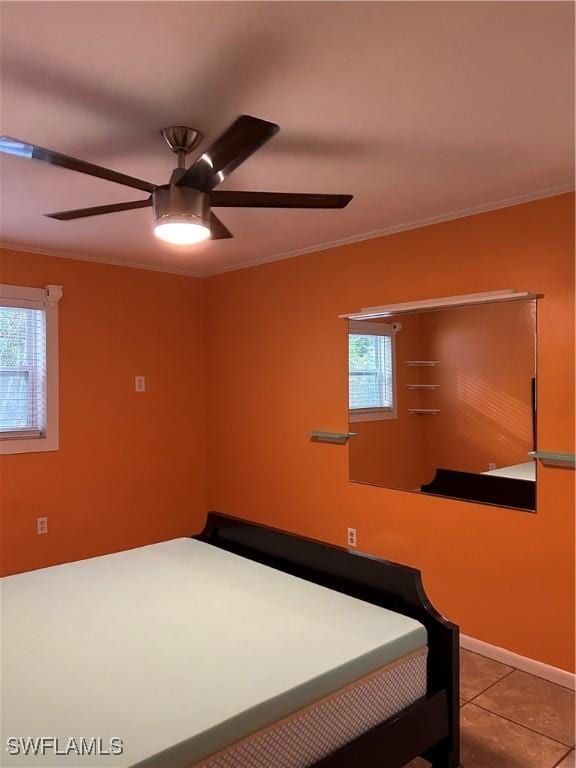 tiled bedroom with crown molding and ceiling fan