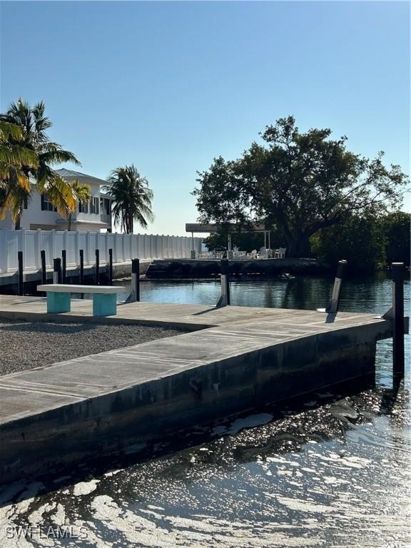 view of dock with fence and a water view