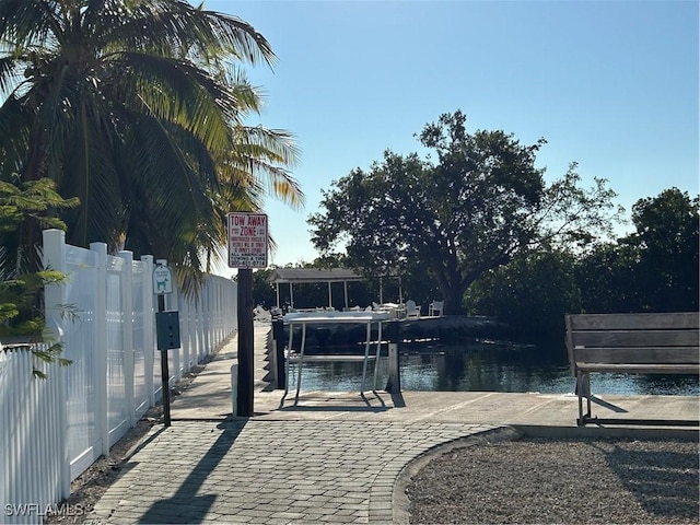 exterior space featuring fence, a water view, and boat lift