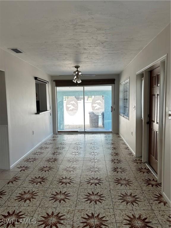 unfurnished room featuring visible vents, baseboards, and a textured ceiling