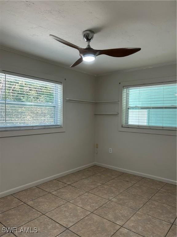 spare room with plenty of natural light, baseboards, a ceiling fan, and ornamental molding