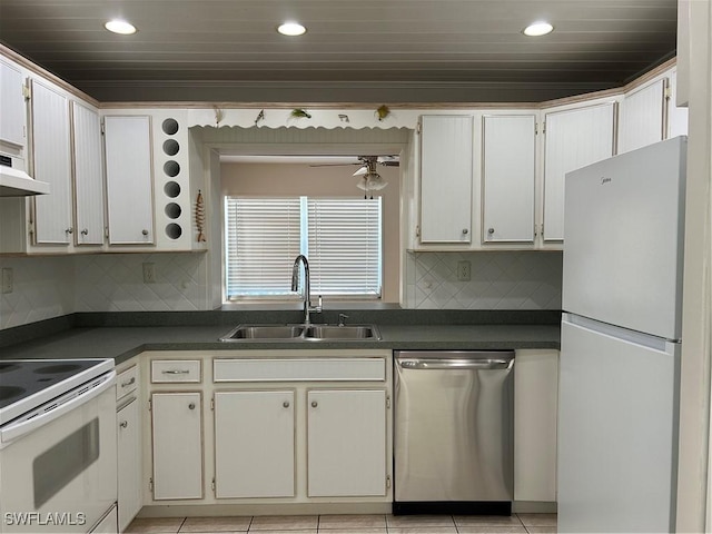 kitchen with dark countertops, tasteful backsplash, ceiling fan, white appliances, and a sink