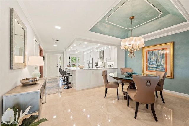 dining room featuring sink, a tray ceiling, crown molding, and a notable chandelier