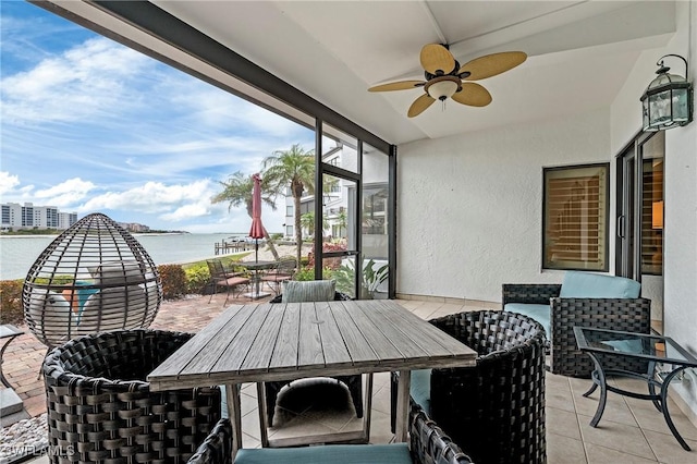 sunroom / solarium with a water view and ceiling fan