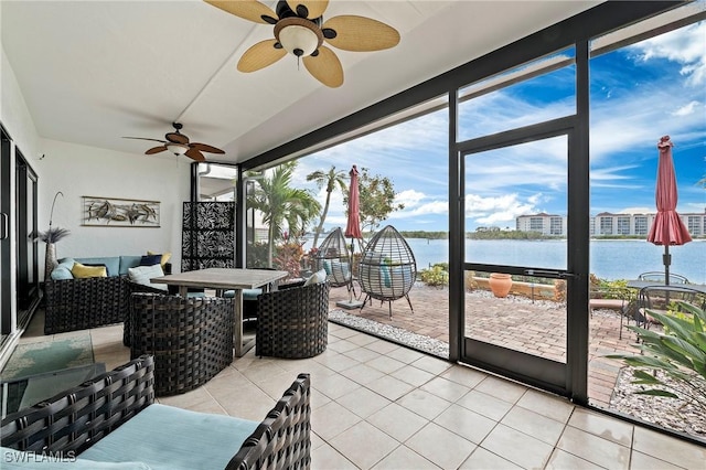 sunroom / solarium featuring ceiling fan and a water view