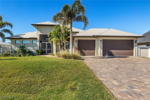 view of front of house featuring a garage and a front lawn