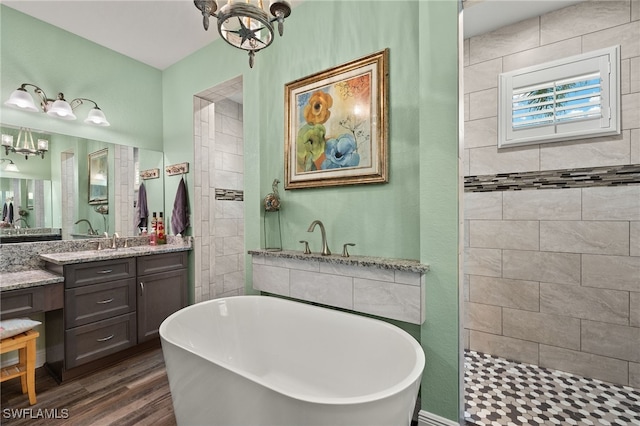 bathroom with hardwood / wood-style floors, vanity, separate shower and tub, and an inviting chandelier