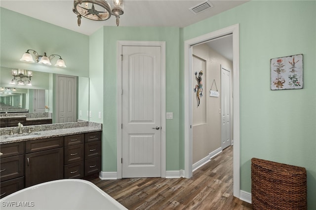 bathroom with vanity, hardwood / wood-style flooring, and a bathtub