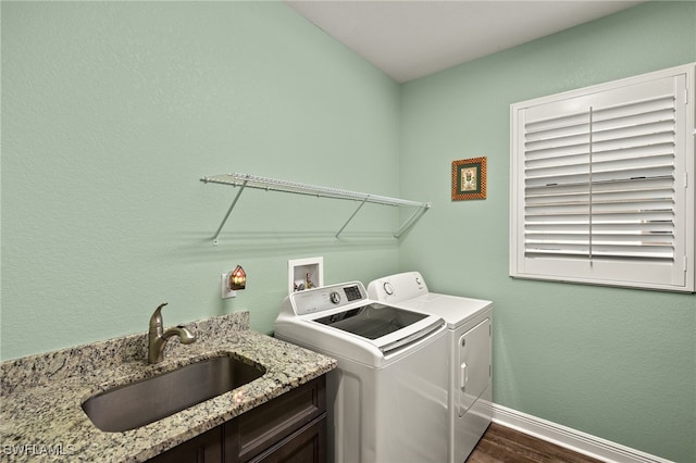 washroom featuring dark hardwood / wood-style flooring, washer and clothes dryer, and sink