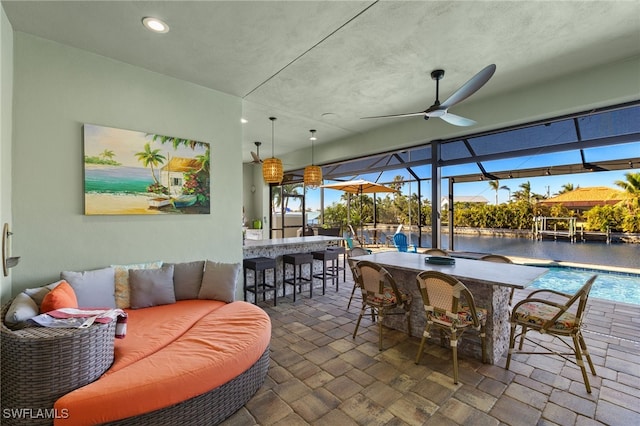 view of patio / terrace with outdoor lounge area, glass enclosure, a water view, and exterior bar