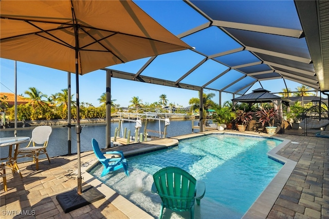 view of swimming pool with glass enclosure, a water view, a dock, and a patio