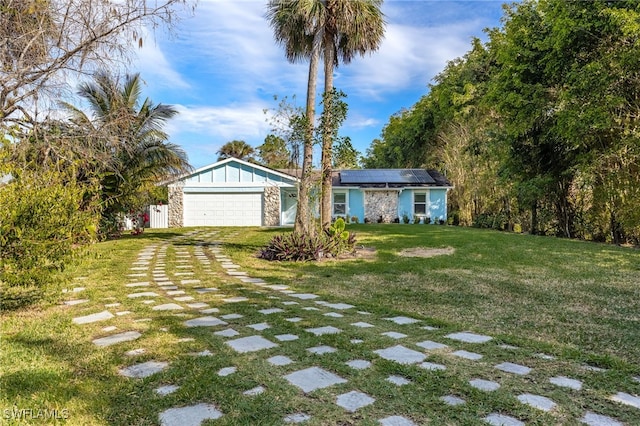 view of front facade featuring solar panels, a front lawn, and a garage