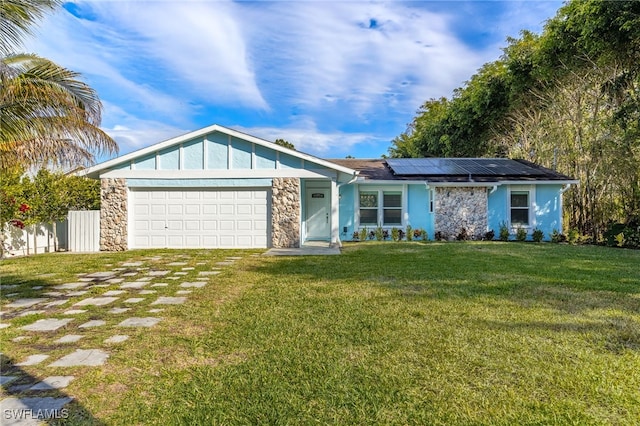 ranch-style home with a garage, a front lawn, and solar panels