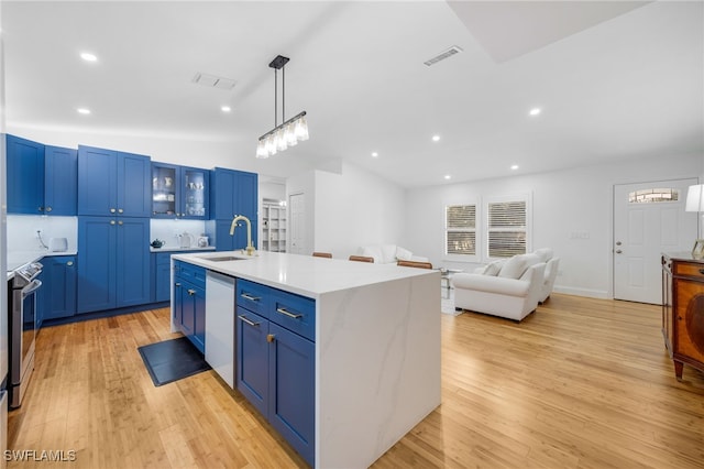 kitchen with stainless steel appliances, a kitchen island with sink, and blue cabinetry