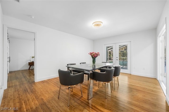 dining area featuring light hardwood / wood-style flooring and french doors