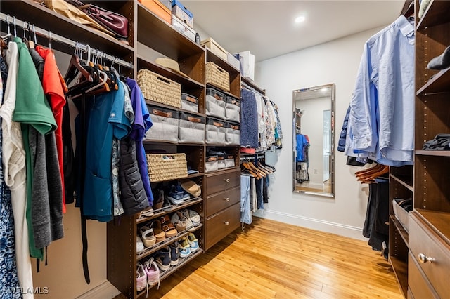 walk in closet with light hardwood / wood-style floors