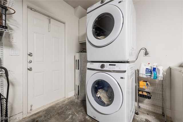 clothes washing area with stacked washing maching and dryer