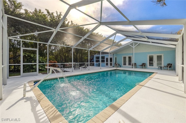 view of pool featuring french doors, pool water feature, glass enclosure, and a patio area