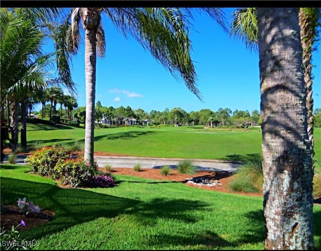 view of home's community with a lawn and view of golf course
