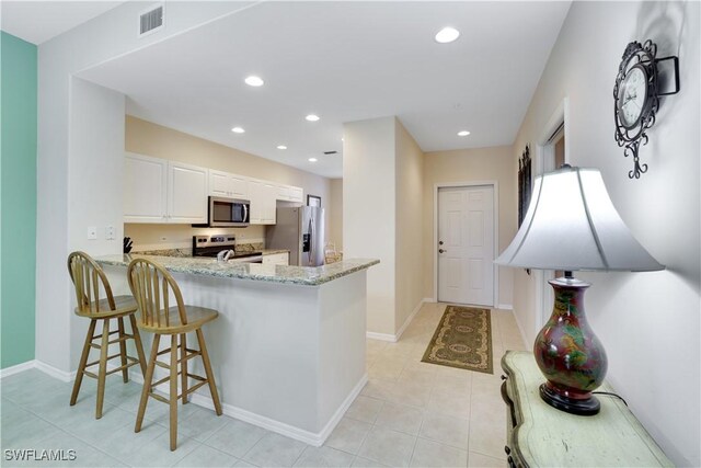 kitchen featuring light stone countertops, appliances with stainless steel finishes, a peninsula, visible vents, and recessed lighting