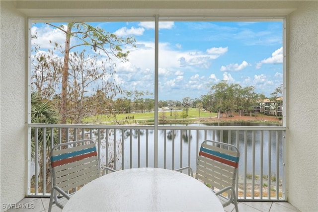 sunroom / solarium featuring a water view