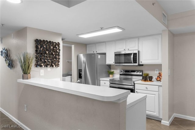 kitchen featuring kitchen peninsula, white cabinetry, independent washer and dryer, and stainless steel appliances