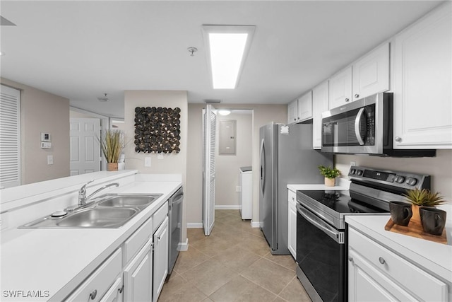 kitchen featuring appliances with stainless steel finishes, sink, white cabinets, washer / clothes dryer, and light tile patterned flooring