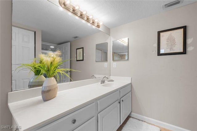 bathroom with vanity and a textured ceiling