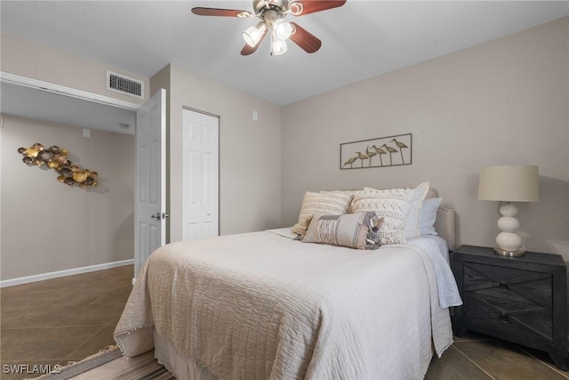 tiled bedroom with ceiling fan and a closet