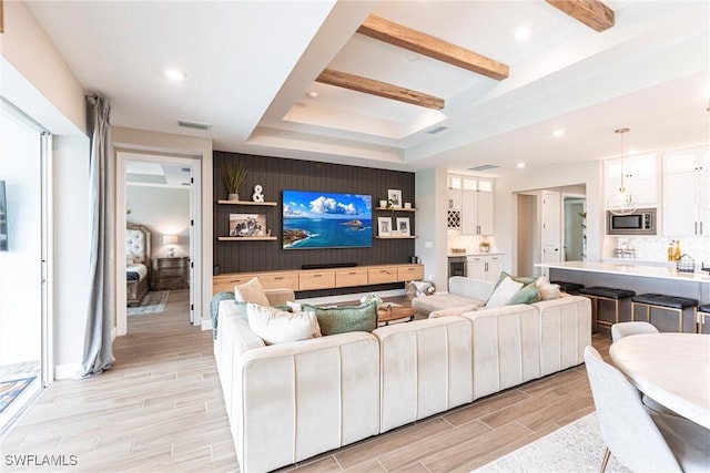 living room with a raised ceiling and beamed ceiling