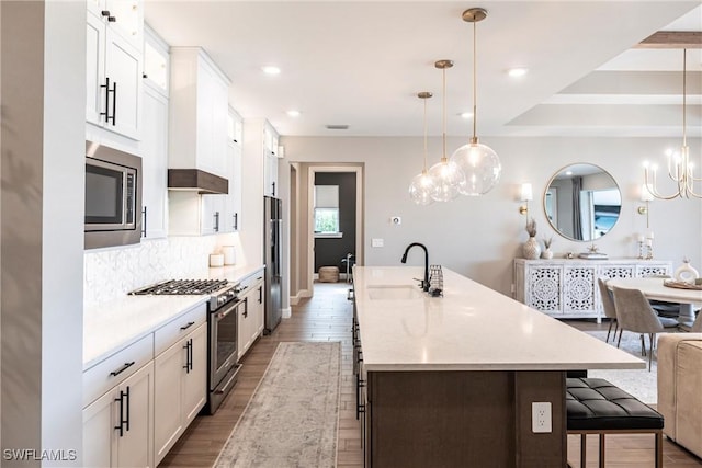 kitchen with white cabinetry, a spacious island, pendant lighting, and stainless steel appliances