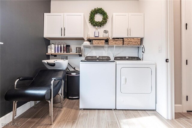 washroom with cabinets and washing machine and dryer