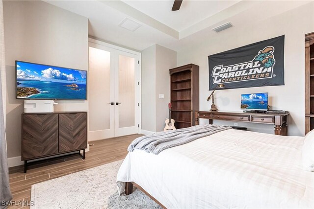 bedroom featuring ceiling fan, french doors, and hardwood / wood-style floors