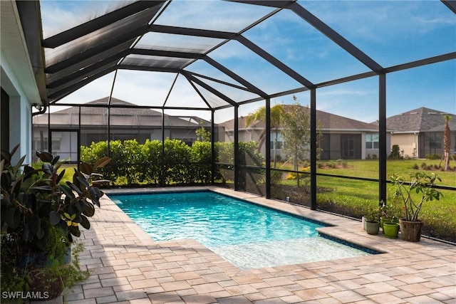 view of swimming pool with glass enclosure and a patio