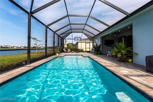 view of swimming pool with a water view, glass enclosure, ceiling fan, and a patio area