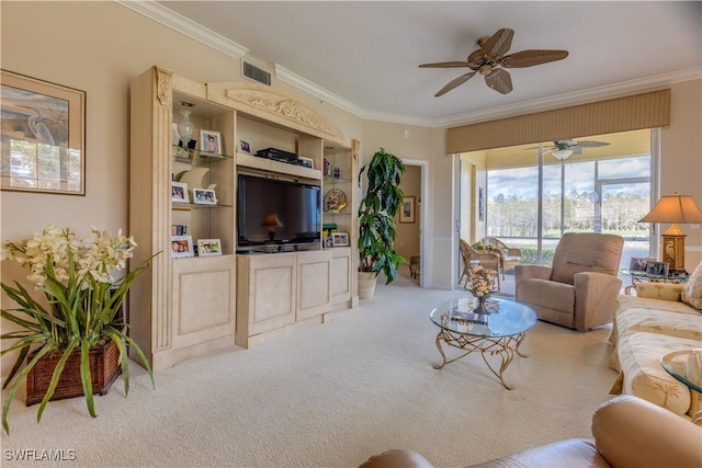 living room featuring ceiling fan, ornamental molding, and carpet floors