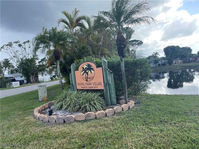 community sign with a yard and a water view