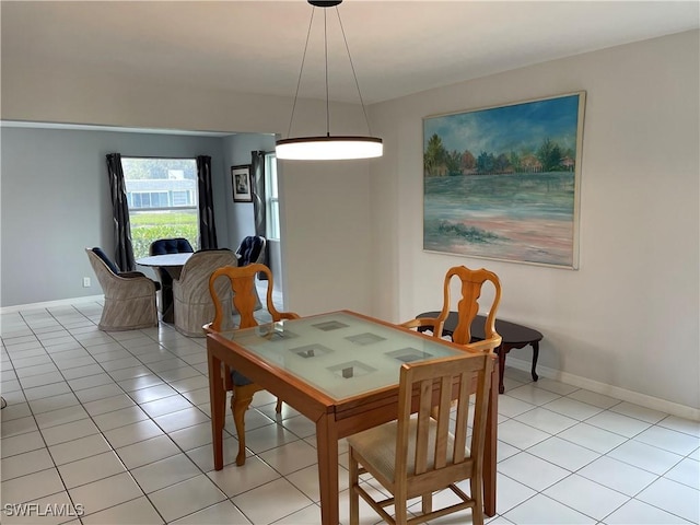 dining space with light tile patterned floors and baseboards