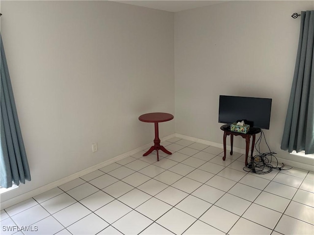 interior space featuring light tile patterned flooring and baseboards