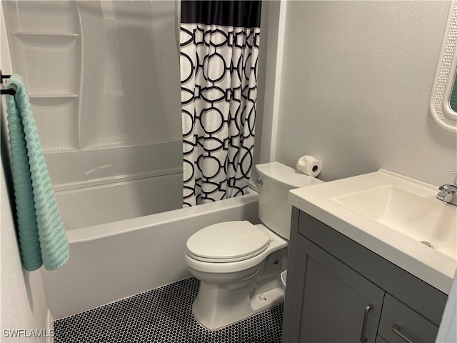 bathroom with shower / bathtub combination with curtain, a textured wall, vanity, and toilet